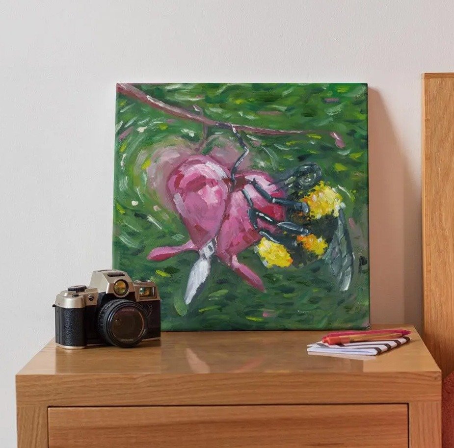 Buzzing Hearts Oil Painting being displayed on an end table